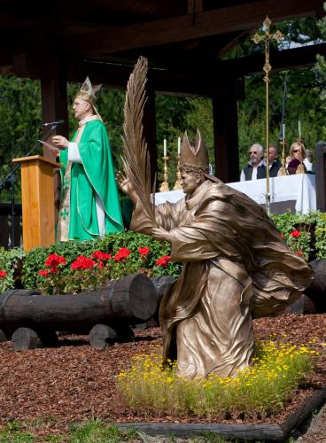 La statua dedicata a Papa Giovanni Paolo II. Dietro, il Cardinale Tarcisio Bertone