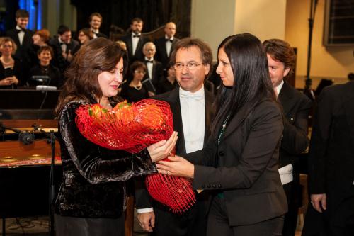 Il Presidente Emily Rini omaggia il soprano Alexandra Zabala con dei fiori. Fra loro, il Maestro Efisio Blanc