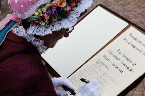 Una "gabençoise" mentre lascia la propria firma in occasione del 60° anniversario del suo paese