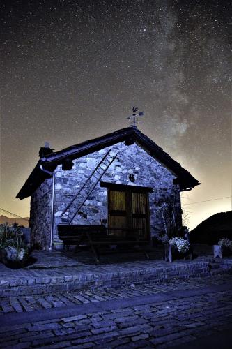 Petite maison  avec Voie lactée en arrière-plan à Loc. Venoz, auteur Mario Borghi, image première classée dans le concours d'astrophotographie dans la catégorie "Panorami tra cielo e terra".